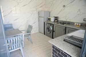 a kitchen with a refrigerator and a table and chairs at BBS Maison in Douz
