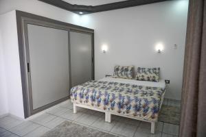a bedroom with a bed and a large sliding door at BBS Maison in Douz