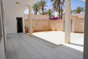 an empty courtyard of a house with palm trees at BBS Maison in Douz