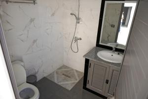 a bathroom with a toilet and a sink and a mirror at BBS Maison in Douz