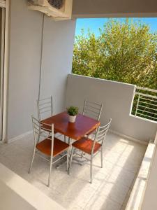 a wooden table and chairs on a patio at Matinas rooms in Nea Mesangala
