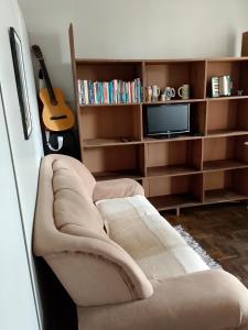 a living room with a couch and a guitar at Hostel Uziel in Timbó