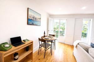 a living room with a desk and a table with a laptop at Cc House Porto in Porto