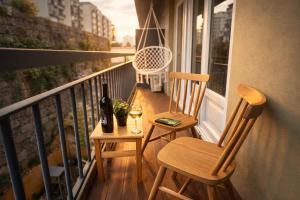 a balcony with two chairs and a bottle of wine at Cc House Porto in Porto