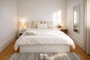 a white bedroom with a large white bed and a rug at Cc House Porto in Porto