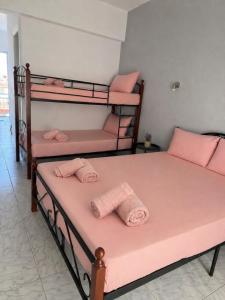 two bunk beds in a room with pink sheets at Matinas rooms in Nea Mesangala