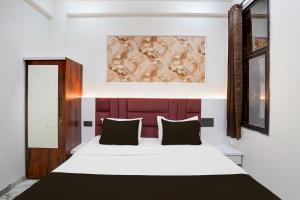 a bedroom with a bed and a painting on the wall at Hotel O S.P Residency in Indore +29 photos