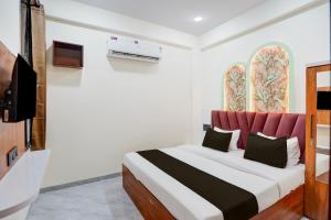 a bedroom with a large bed with a red headboard at Hotel O S.P Residency in Indore