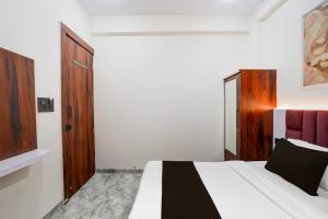 a bedroom with a bed with a black and white blanket at Hotel O S.P Residency in Indore