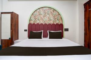 a bedroom with a large bed with a red headboard at Hotel O S.P Residency in Indore