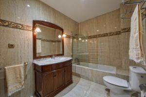 a bathroom with a sink and a toilet and a tub at Casa Rural EL COTARRO DE PESQUERA DE DUERO in Pesquera de Duero