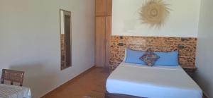 a bedroom with a bed with blue pillows at Darna 2 in Demina