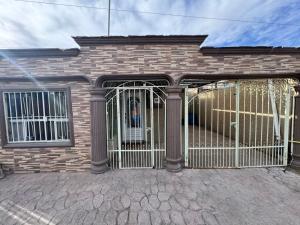 a gate in the front of a brick house at Casa visas656 in Manuel F. Martínez