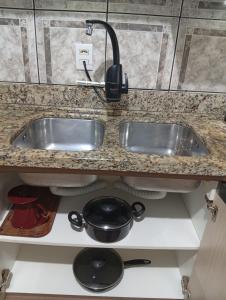 a kitchen counter with a sink and a pot at Casa Zibell centro de Pomerode in Pomerode +27 photos