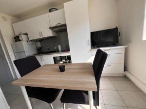 a dining room table with black chairs and a television at La Studette Marina 06 in Villeneuve-Loubet +12 photos