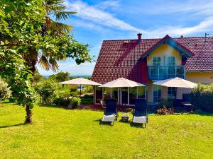 two chairs and umbrellas in front of a house at Gästehaus Helbighof in Neustadt an der Weinstraße