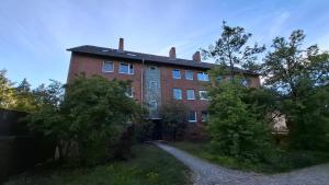a large red brick building with a driveway at 2 Zimmer Apartment - zentral und ruhig - nahe VW, Autostadt, Parkplatz & WLAN, CityStay Wolfsburg - GTI in Wolfsburg