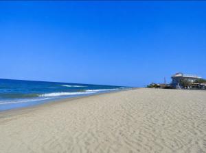 a sandy beach with the ocean in the background at Matinas rooms in Nea Mesangala