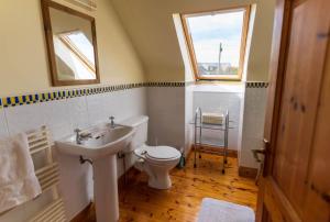 a bathroom with a sink and a toilet and a window at Lakehouse Waterville in Waterville +14 photos