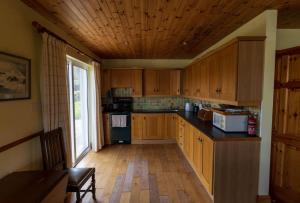 a kitchen with wooden cabinets and a wooden ceiling at Lakehouse Waterville in Waterville