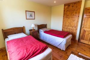 two beds in a room with wooden floors at Lakehouse Waterville in Waterville