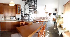 a kitchen and living room with a table and a staircase at VintageVilla in Skala Marion