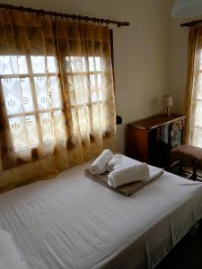 a bed with two towels on it with a window at VintageVilla in Skala Marion