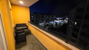 a room with a chair on a balcony at night at Art Apartment in Prizren