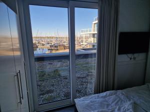 a bedroom with a window with a view of a harbor at Ferienwohnung Austernfischer Marina Wendtorf in Wendtorf