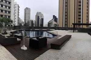 a rooftop patio with couches and a pool on a building at Refúgio Morumbi: Piscina aquecida e espaço gourmet in São Paulo