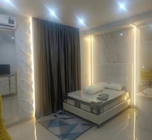 a white bedroom with a bed with lights on it at Cozzy Aryaputra Residence in Gorontalo