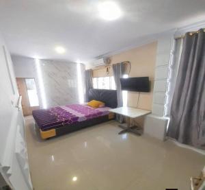 a small bedroom with a bed and a desk at Cozzy Aryaputra Residence in Gorontalo