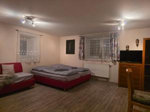a living room with two beds and a couch at Apartmán na statku NH Stables in Nýřany