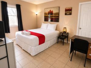 a bedroom with a large white bed and a desk at Skylark Motel by OYO in Bedford