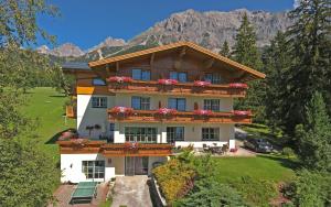 een huis met bloemen op de balkons bij Alpenperle in Ramsau am Dachstein