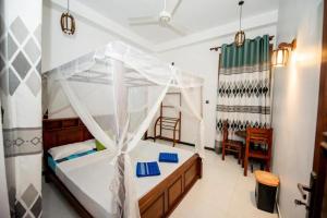 a bedroom with a bed with a canopy at Wake N Flow, Hiriketiya Beach in Hiriketiya