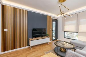 a living room with a couch and a tv at Luxury Apartment Bar in Šušanj