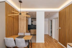 a dining room and kitchen with a table and chairs at Luxury Apartment Bar in Šušanj +9 photos