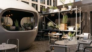 a restaurant with tables and chairs and a building at Ruby Luna Hotel Dusseldorf by IHG in Düsseldorf +79 photos