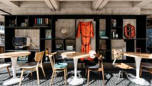 a room with tables and chairs and a wall with shelves at Ruby Luna Hotel Dusseldorf by IHG in Düsseldorf