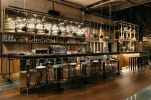 a bar with bar stools in a room at Ruby Luna Hotel Dusseldorf by IHG in Düsseldorf