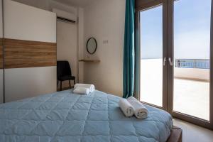a bedroom with a large bed with towels on it at Kaliva Villa in Kerames +64 photos