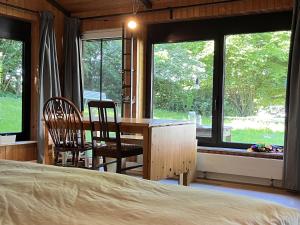 ein Schlafzimmer mit Bett, Schreibtisch und Fenstern in der Unterkunft Datscha in Eutin