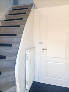 a staircase with a white door and a white stair case at Haus Falk in Zarpen