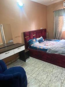 a bedroom with a bed and a desk and a mirror at Hanover Hotels Suleja in Tunga Bai +4 photos