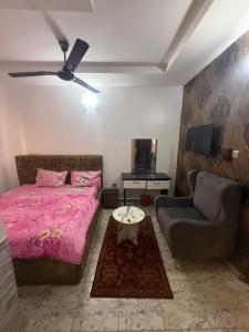 a bedroom with a pink bed and a couch at Hanover Hotels Suleja in Tunga Bai