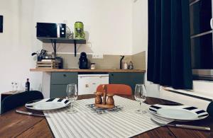 a dining room table with two plates and wine glasses at Chouett'studio in Dijon