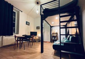 a bedroom with a bunk bed and a dining room at Chouett'studio in Dijon