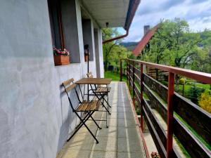 a porch with two chairs and a table on a balcony at Chatička Lukov in Lukov +36 photos