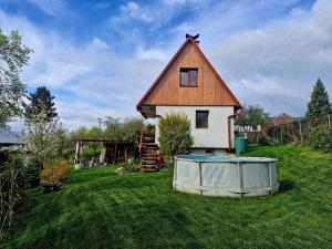 a small house with a gambrel roof on a yard at Chatička Lukov in Lukov